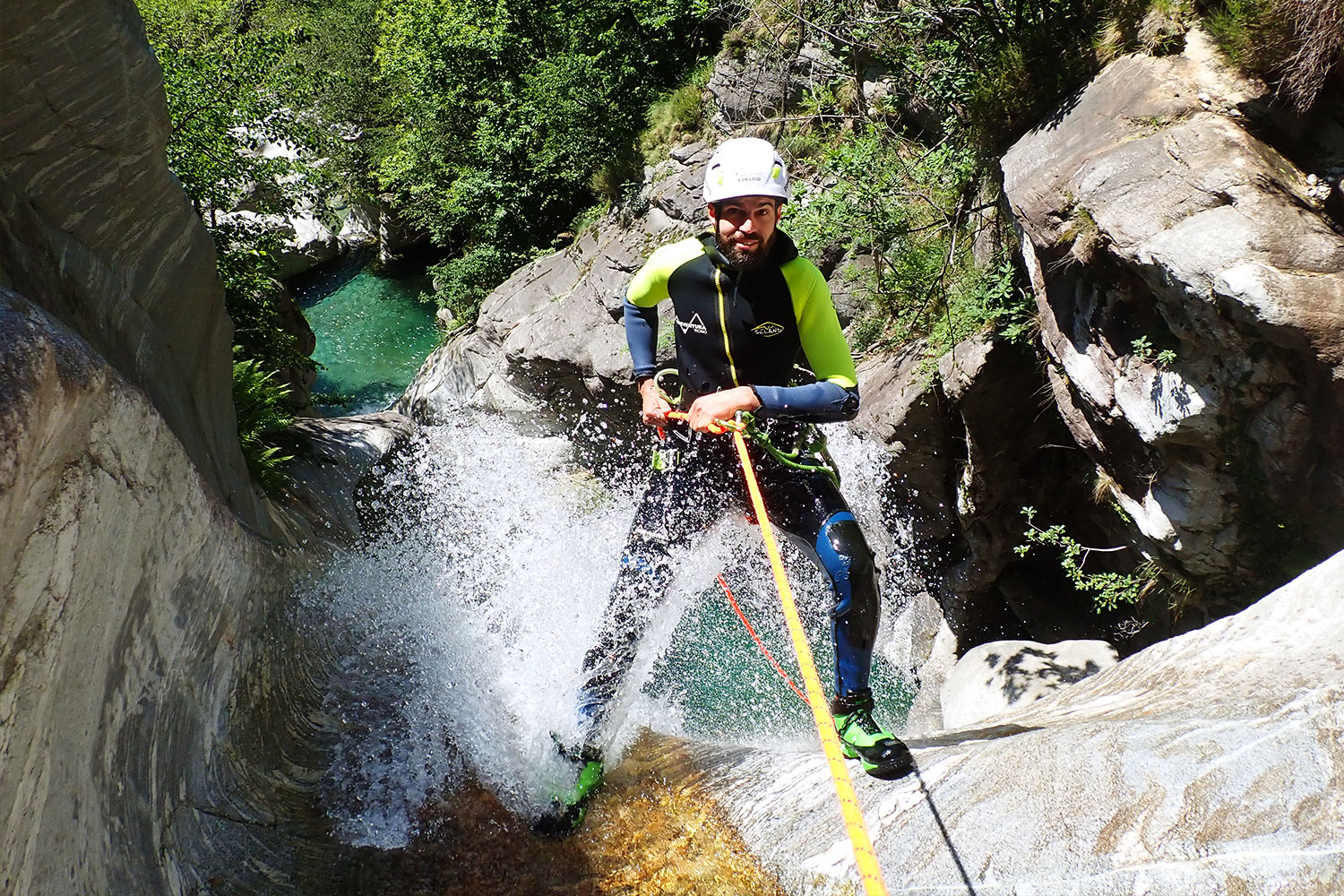 Mitten im Moment: Canyoning in Cresciano bedeutet Action, Technik und Natur pur – sicher begleitet von purelements®. Teilnehmer beim Abseilen durch eine Wasserfallrinne im Boggera-Canyon in Cresciano – Canyoning mit purelements® im Tessin